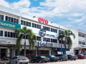 a building with cars parked in a parking lot at Okid Hotel in Johor Bahru