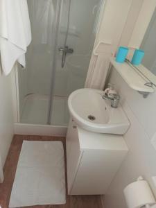 a white bathroom with a sink and a shower at Camping Torkul in Kraj