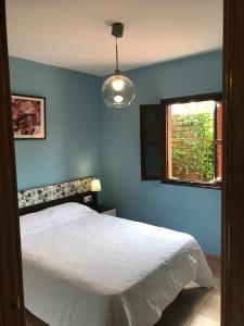 a blue bedroom with a bed and a window at Casa Rural Llanes - Hontoria in Hontoria