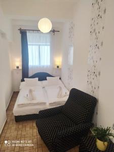 ハイドゥソボスローにあるMarabella Apartmanokのベッドルーム1室(ベッド1台、椅子付)
