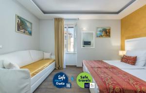 a hotel room with two beds and a couch at Boutique Hotel Melissa in Poreč
