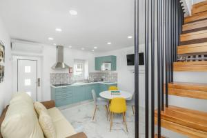 a kitchen and living room with a table and yellow chairs at Maredimo Village Porto Casa 5 in Porto