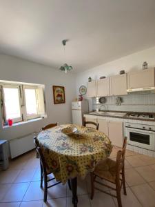 a kitchen with a table and chairs and a kitchen with white cabinets at La Casina in Siculiana