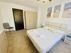 sypialnia z dużym białym łóżkiem i krzesłem w obiekcie A886 - Entreplayas - 2004 Finestrat s.l. w mieście Cala de Finestrat +23 zdjęcia