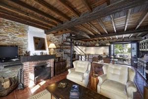 een woonkamer met 2 stoelen en een open haard bij Casa La Palomba in El Pito