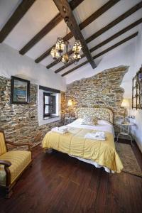 a bedroom with a large bed and a stone wall at Casa La Palomba in El Pito