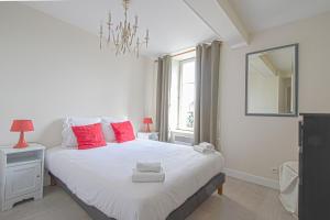 sypialnia z dużym białym łóżkiem z czerwonymi poduszkami w obiekcie IKE'S Deluxe APARTMENT in Bayeux w mieście Bayeux