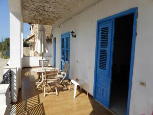 ヴィッラッジョ・モセにあるPiccoledonneの青いドアとテーブルと椅子付きのポーチ