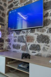 een flatscreen-tv zittend op een plank bij Sokaki House in Hydra