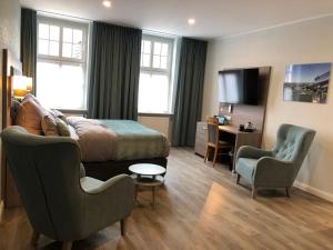 um quarto de hotel com uma cama, uma secretária e cadeiras em AKZENT Hotel Restaurant Roter Ochse Rhens bei Koblenz em Rhens