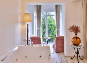 a white bath tub in a room with a large window at Park Mandalin Hotel - Adult only in Ağva