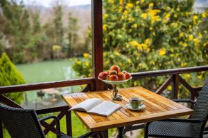 a table with a bowl of fruit and a book on a balcony at Park Mandalin Hotel - Adult only in Ağva
