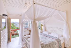 a bedroom with a white canopy bed and a balcony at Park Mandalin Hotel - Adult only in Ağva