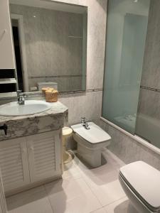 a bathroom with a sink and a toilet and a mirror at BLAU Bonito Duplex con Terraza in Calella de Palafrugell +19 photos