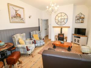 a living room with a couch and chairs and a fireplace at The Hideout in Oakham