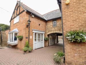 a brick building with a white door and a courtyard at The Hideout in Oakham