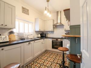 a kitchen with white cabinets and a stove top oven at The Hideout in Oakham