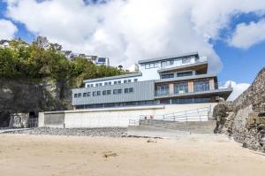 a building on the beach in front of a building at No 3 Ocean Cabins Bunk Bed - Saundersfoot Harbour in Saundersfoot