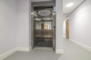 a hallway in an office building with a elevator at No 3 Ocean Cabins Bunk Bed - Saundersfoot Harbour in Saundersfoot