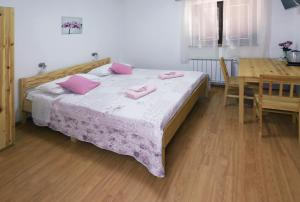 um quarto com uma cama com almofadas cor-de-rosa em Guesthouse Sanabor em Postojna