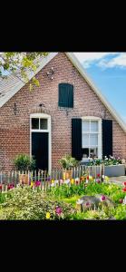 a brick house with flowers in front of it at Erve de Kippe. Vrij maar toch dichtbij. in Epse
