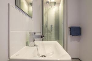 een witte badkamer met een wastafel en een douche bij No 4 Ocean Cabins - Saundersfoot Harbour - Saundersfoot in Saundersfoot