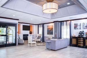 vestíbulo con sofá, sillas y lámpara de araña en Clarion Hotel & Conference Center Leesburg, en Leesburg
