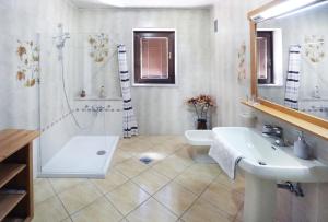 a bathroom with a sink and a shower and a toilet at Guesthouse Sanabor in Postojna
