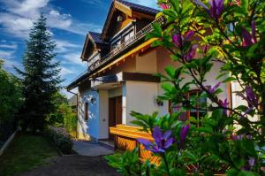 a house with a balcony and purple flowers at Ferienhaus Bodensee Seeblick in Gaienhofen