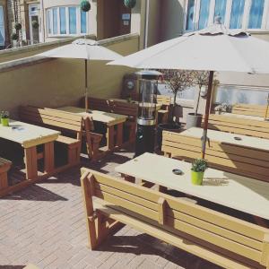 a group of tables and benches with an umbrella at Hotel No 8 in Skegness