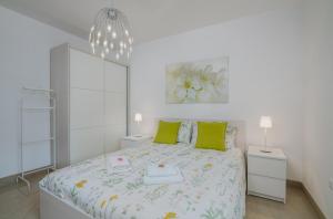 biała sypialnia z dużym łóżkiem z zielonymi poduszkami w obiekcie Villa Ada Malinska w mieście Malinska