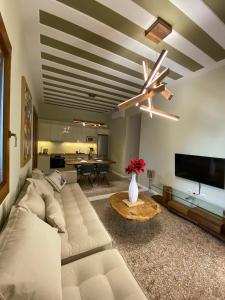 a living room with a white couch and a ceiling fan at Andros 4 All Seasons Villas & Suites in Andros