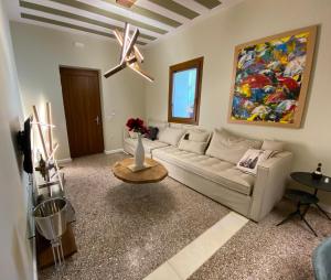 a living room with a white couch and a painting at Andros 4 All Seasons Villas & Suites in Andros