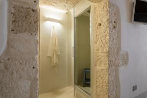a bathroom with a shower with a glass door at Cementine Traditional Suites by Wonderful Italy in Ostuni