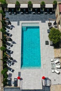 einen Blick über einen Pool mit Liegestühlen in der Unterkunft Hôtel L'Abbaye in Calvi