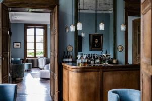 eine Bar in einem Raum mit blauen Wänden in der Unterkunft Domaine de Primard - Fontenille Collection in Guainville