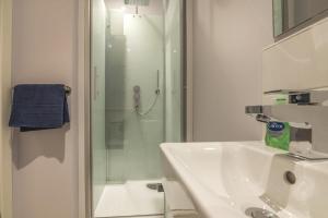 a white bathroom with a sink and a shower at No 9 Ocean Cabins - Saundersfoot Harbour - Saundersfoot in Saundersfoot