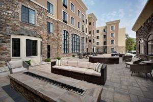 a patio with a couch and chairs in front of a building at Staybridge Suites - Southgate - Detroit Area by IHG in Southgate