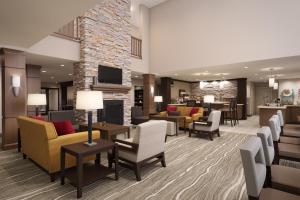 南門的住宿－Staybridge Suites - Southgate - Detroit Area, an IHG Hotel，一个带沙发和椅子的酒店大堂