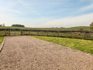 a gravel road in a field with a fence at Shepherds Retreat in Ashbourne +10 photos