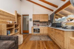 una cucina con armadi in legno e un soggiorno di Chalet Mountain Plaza - Apt Overland a Pinzolo