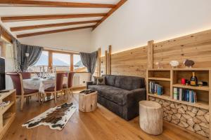 ein Wohnzimmer mit einem Sofa und einem Tisch in der Unterkunft Chalet Mountain Plaza - Apt Overland in Pinzolo