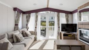 - un salon avec un canapé et une télévision dans l'établissement Hotel du Van, à Poole
