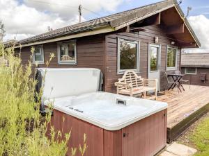 a hot tub sitting on a deck next to a house at Avallon Lodges in Launceston