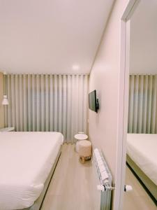 um quarto com duas camas e um banco em Maré Viva Bed & Breakfast em Rego da Leirosa