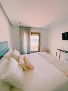 a bedroom with a large white bed with pillows at Maré Viva Bed & Breakfast in Rego da Leirosa