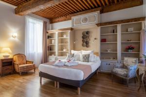 羅納河畔沙斯的住宿－LE DOMAINE DE GORNETON，一间卧室配有一张大床和两把椅子