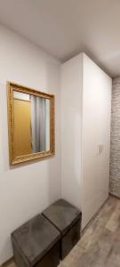 a room with a mirror on the wall and a bench at Apartamentai prie Akropolio gražiu vaizdu į miesta in Klaipėda +6 photos