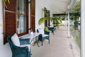 een patio met stoelen, een tafel en een tafel bij Heritage House in Stellenbosch