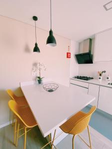 eine Küche mit einem weißen Tisch und Stühlen in der Unterkunft Maré Viva Bed & Breakfast in Rego da Leirosa